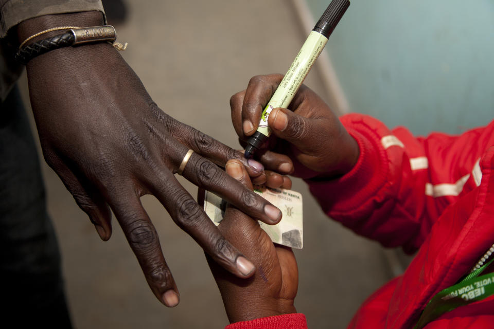 A polling official marks a voter’s finger