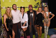 <p>Even though Miley was practically naked at the 2015 MTV VMAs, it didn’t deter her family from rallying around in support. The evening’s host — wearing this racy number — posed with her crew (from left, Tish, brother Braison, Noah, Billy Ray, and Brandi) backstage. (Photo: Larry Busacca/Getty Images) </p>