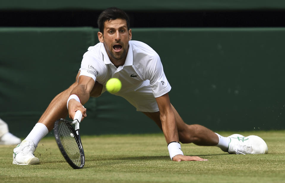 Serbia's Novak Djokovic returns to Spain's Roberto Bautista Agut in a Men's singles semifinal match on day eleven of the Wimbledon Tennis Championships in London, Friday, July 12, 2019. (Andy Rain/Pool Photo via AP)