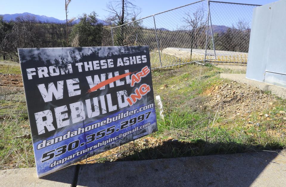 In 2020, a sign in the Carr Fire burn area near the corner of Americana Way and Spinnaker Drive in Redding reads, "From these ashes we are rebuilding."