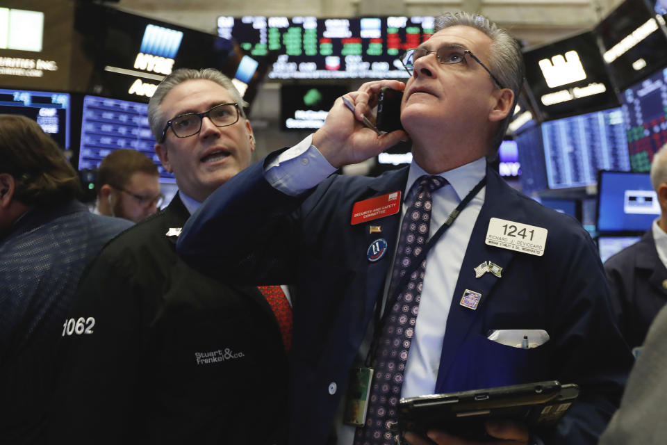 Traders Eric Schumacher, left, and Richard Deviccaro work on the floor of the New York Stock Exchange, Thursday, Nov. 8, 2018. Stocks are opening modestly lower on Wall Street as the market gives back some of its big gains from the day before. (AP Photo/Richard Drew)