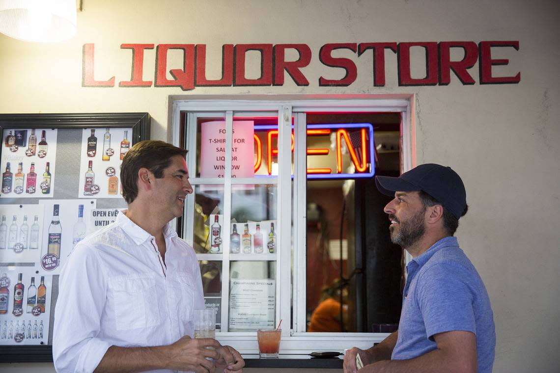 Peter Spillis, 49, and Rashid Siahpoosh, 44, make a purchase from the original liquor store window at Fox’s Lounge in 2015. The liquor windows at the revived Fox’s Lounge will face US-1 instead of the alley.