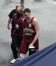 Denver Nuggets center Nikola Jokic, front, is escorted from the court after being ejected for a flagrant foul in the second half of Game 4 of an NBA second-round playoff series against the Phoenix Suns Sunday, June 13, 2021, in Denver. (AP Photo/David Zalubowski)