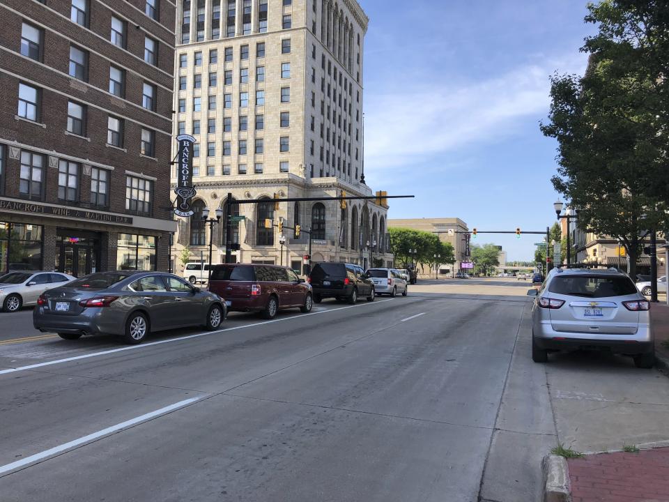 In this July 17, 2019 photo, cars line a street in downtown Saginaw, Michigan. The city has been working for decades to reinvent itself after the decline of the auto industry, with mixed results. President Donald Trump is campaigning on the improved economy as he seeks re-election, while Democrats argue not everyone has enjoyed the benefits. Economic conditions in Michigan could be crucial in determining whether Democrats retake a state they once held for decades (AP Photo/Sara Burnett)