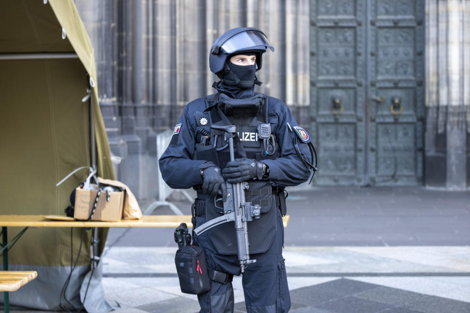 Before the end-of-year pontifical mass in Cologne Cathedral with Cardinal Woelki, the area around the cathedral is heavily guarded by police with machine guns, Sunday, Dec. 31, 2023. German authorities say they have detained three more people in connection with a reported threat to Cologne Cathedral over the holiday period. (Thomas Banneyer/dpa via AP)