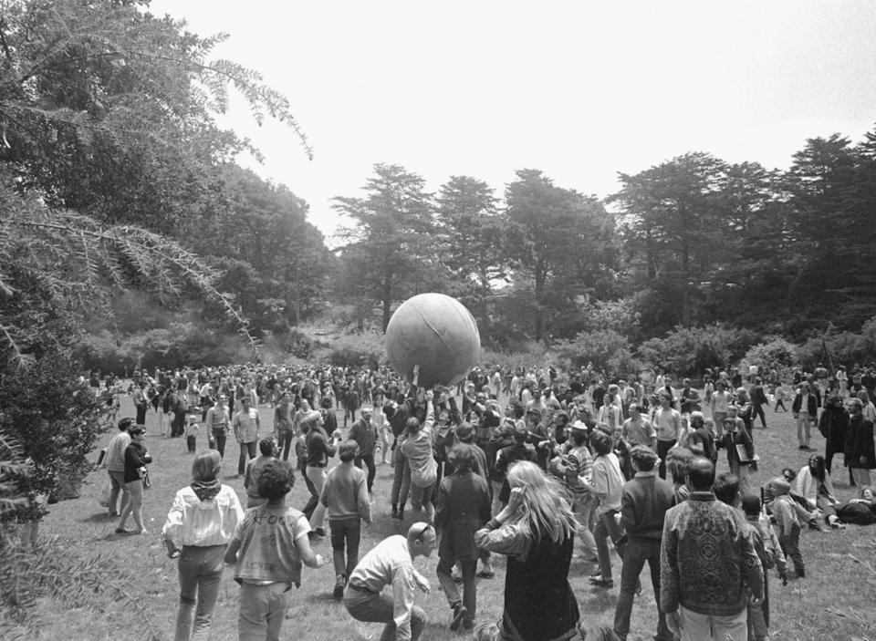 FILE - In this June 21, 1967, file photo, people keep a large ball, painted to represent a world globe, in the air during a gathering at Golden Gate Park in San Francisco, to celebrate the summer solstice, Day 1 of the "Summer of Love." Golden Gate Park turned 150 years old on Saturday, April 4, 2020, and the huge party to celebrate San Francisco's beloved treasure will, for the time being, take place online. (AP Photo/File)