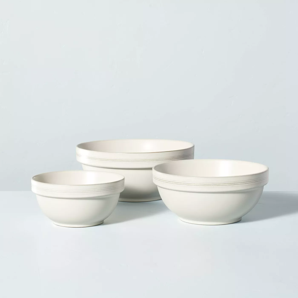 Three white mixing bowls on blue backdrop