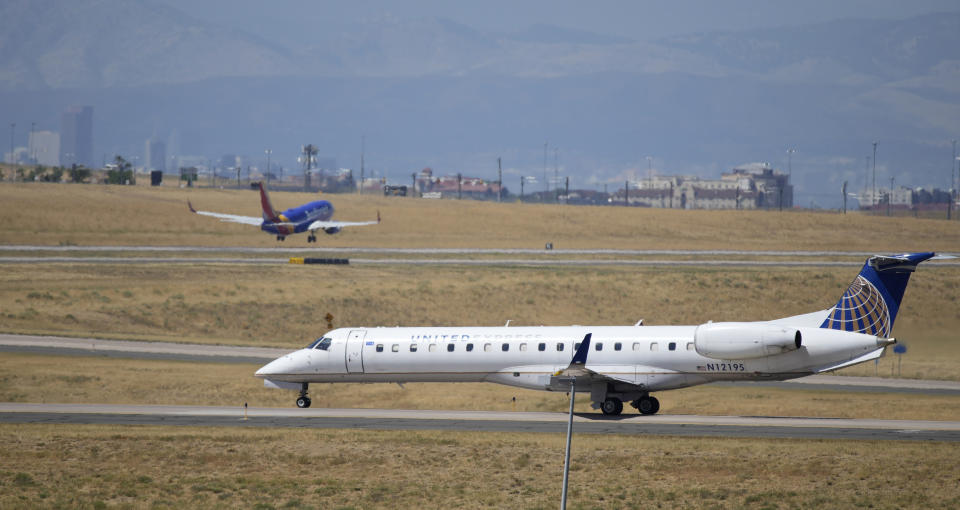 A United Express jet taxis down a runway as a Southwest Airlines plane takes off in the background at Denver International Airport, Tuesday, Aug. 24, 2021, in Denver. Two months after the Sept. 11, 2001 attacks, President George W. Bush signed legislation creating the Transportation Security Administration, a force of federal airport screeners that replaced the private companies that airlines were hiring to handle security. (AP Photo/David Zalubowski)