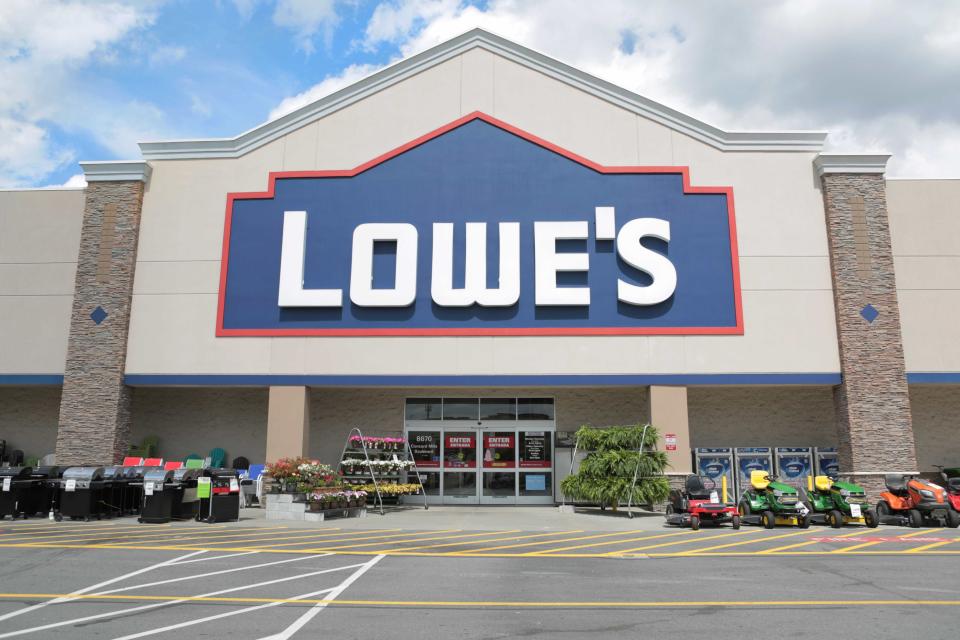 Lowe's storefront with lawn mowers and plants.