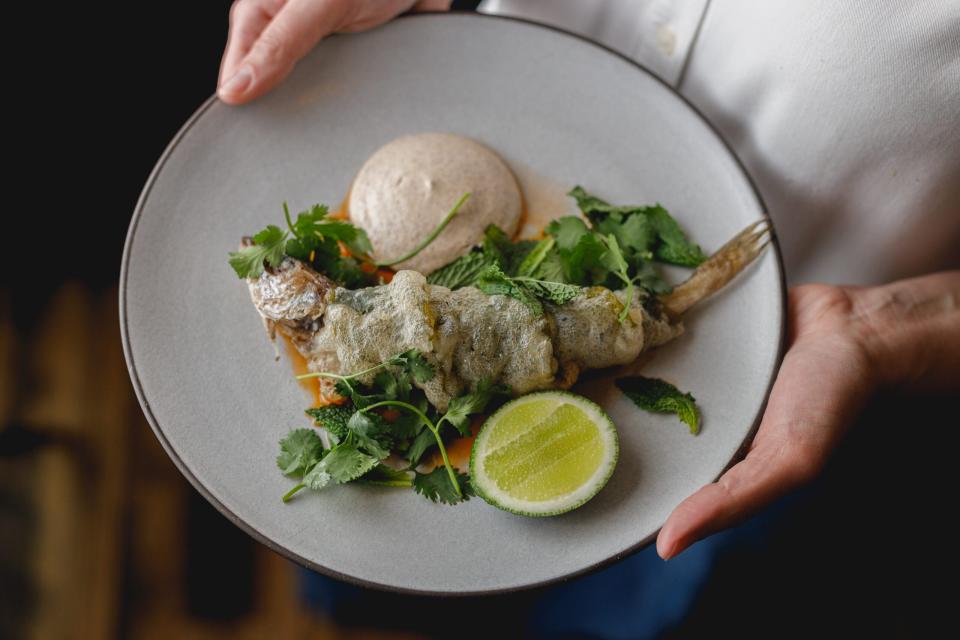 A filet of a fish called whiting, with various greens and a side of lime.