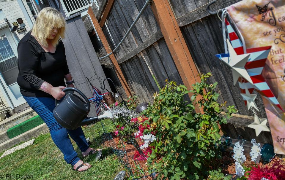 Corina Drury waters flowers in the backyard of her South Mulberry Street home in Hagerstown. It's the first home of her own in 13 years.