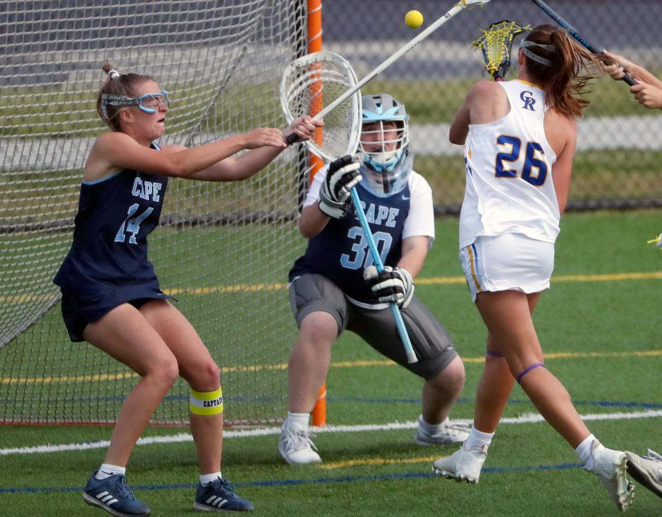 Cape Henlopen's Mackinzie Brown (left) and Anna Lopez try to repel a shot by Caesar Rodney's Ella Brown in the second half of Cape Henlopen's 17-6 win at Caesar Rodney, Wednesday, April 26, 2023.