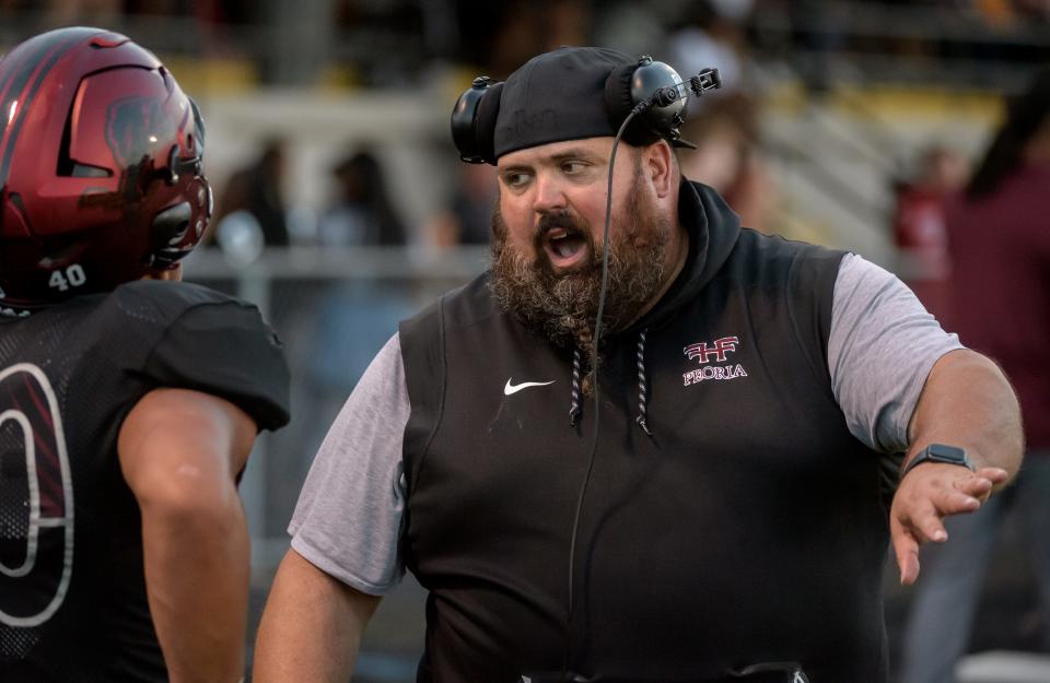 Peoria High head football coach Tim Thornton doles out some advice to one of his players in the first half Friday, Aug. 26, 2022 at Peoria Stadium.