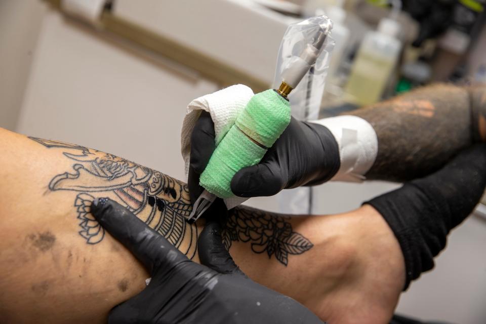 Dave Shoemaker, tattooist and owner of Ninth Wave Tattoo, works on a custom tattoo for Jonathan Quinones-Verace of Farmingdale as he talks about his business in Asbury Park, NJ Thursday, October 20, 2022. 