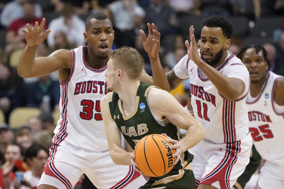 UAB's Michael Ertel, center, looks to get the ball past Houston's Fabian White Jr. (35) and Kyler Edwards (11) as they defend during the first half of a college basketball game in the first round of the NCAA tournament, Friday, March 18, 2022, in Pittsburgh. (AP Photo/Keith Srakocic)