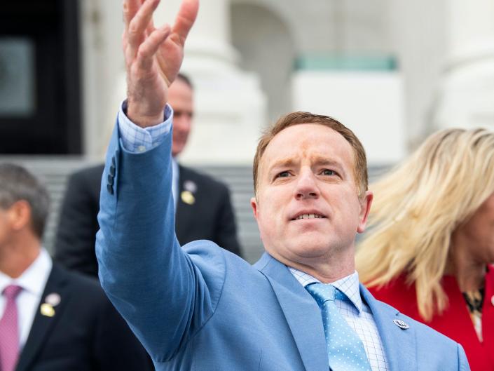 Rep. Pat Fallon, a Republican from Texas, is waving his right hand and wearing a light blue suit during a group photo with freshmen members of the House Republican Conference on the House steps of the US Capitol on January 4, 2021.