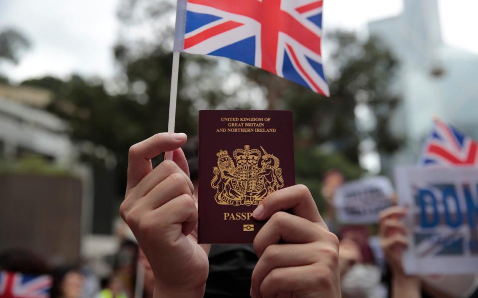  A protestor holds up his British passport and participates in a peaceful demonstration outside the British Consulate in Hong Kong, Sunday, Sept. 1, 2019 - Jae C. Hong/AP