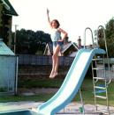 <p>Always poised, even when jumping off a slide into the family’s pool at Park House, a youthful Diana shows off her fun side. Her red swimming badges can be seen at the bottom of her bathing suit.</p>