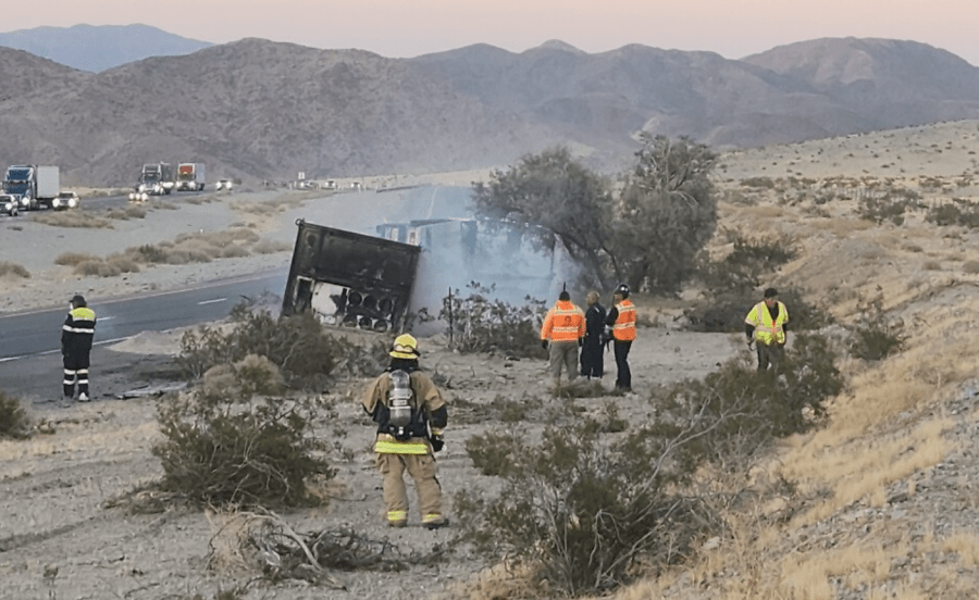 Emergency personnel, firefighters and hazardous materials specialists respond to the scene of an overturned big rig carrying lithium batteries that caught fire, causing a massive traffic backup on the I-15 Freeway on July 27, 2024. (California Highway Patrol Barstow)