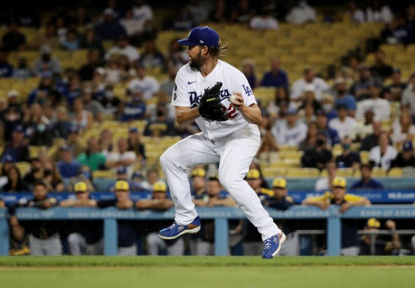 LOS ANGELES, CA - OCTOBER 1, 2021: Los Angeles Dodgers starting pitcher Clayton Kershaw (22) fields a grounder hit by Milwaukee Brewers third baseman Luis Urias (2) Milwaukee Brewers at Dodger Stadium on October 1, 2021 in Los Angeles, California.(Gina Ferazzi / Los Angeles Times)