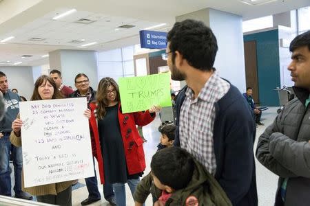 People with signs welcome travellers at Dallas/Fort Worth International Airport international arrivals gate in Dallas, Texas, U.S. February 4, 2017. REUTERS/Laura Buckman