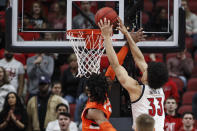 Louisville forward Jordan Nwora (33) goes for a dunk as he's fouled by Syracuse forward Quincy Guerrier (1) during the first half of an NCAA college basketball game Wednesday, Feb. 19, 2020, in Louisville, Ky. (AP Photo/Wade Payne)