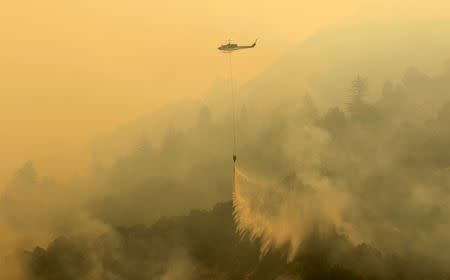 A helicopter makes a water drop during the Soberanes Fire off of Rancho San Carlos Road near Carmel Valley, California, U.S. July 29, 2016. REUTERS/Michael Fiala