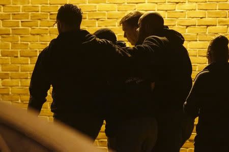 Police officers lead a fellow officer away as he sobbed outside the Prince George's Hospital Center where another officer, shot in the line of duty nearby, was later confirmed killed, in Cheverly, Maryland March 13, 2016. REUTERS/Jonathan Ernst