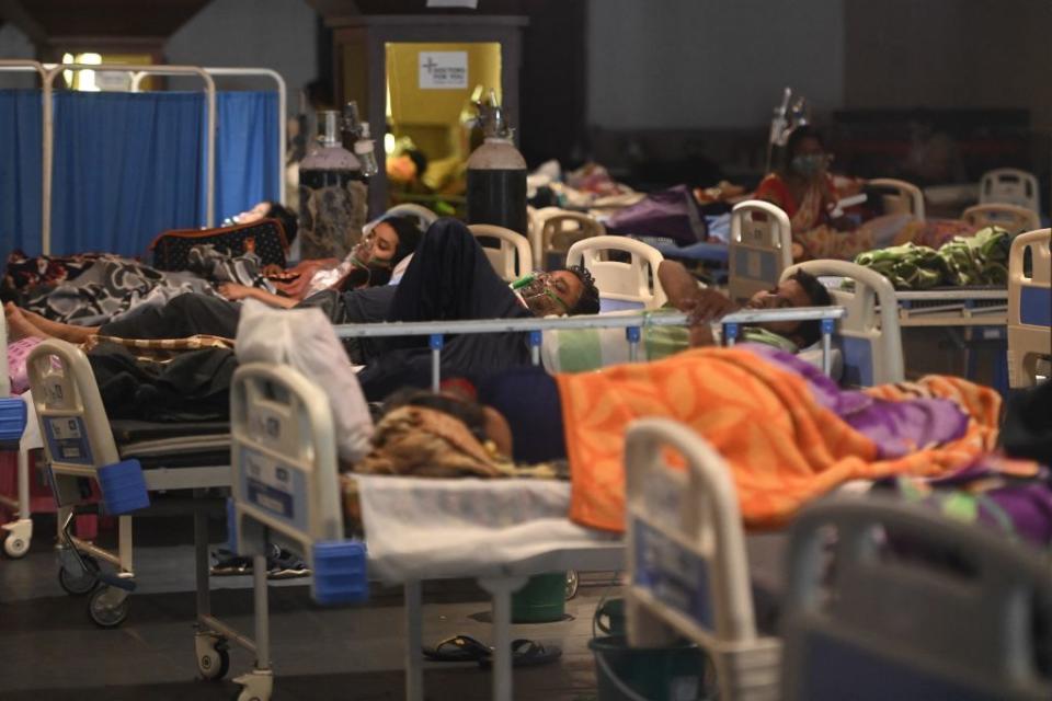 Patients breath with the help of oxygen masks inside a banquet hall temporarily converted into a Covid-19 coronavirus ward in New Delhi on April 27. Source: Getty
