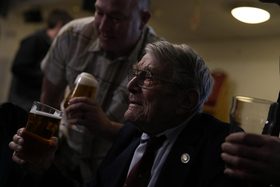 D-Day veteran Bill Gladden has a drink with friends at a surprise 100th birthday party Haverhill, England, Friday, Jan. 12, 2024. Gladden spoke to the AP on the eve of his 100th birthday, he is a veteran of the British 6th Airborne Armoured Reconnaissance Regiment, part of the British 6th Airborne Division, he landed by glider on the afternoon of D-Day, 6th June 1944 in Normandy. The party took place on the eve of his 100th birthday which is the January, 13. (AP Photo/Alastair Grant)