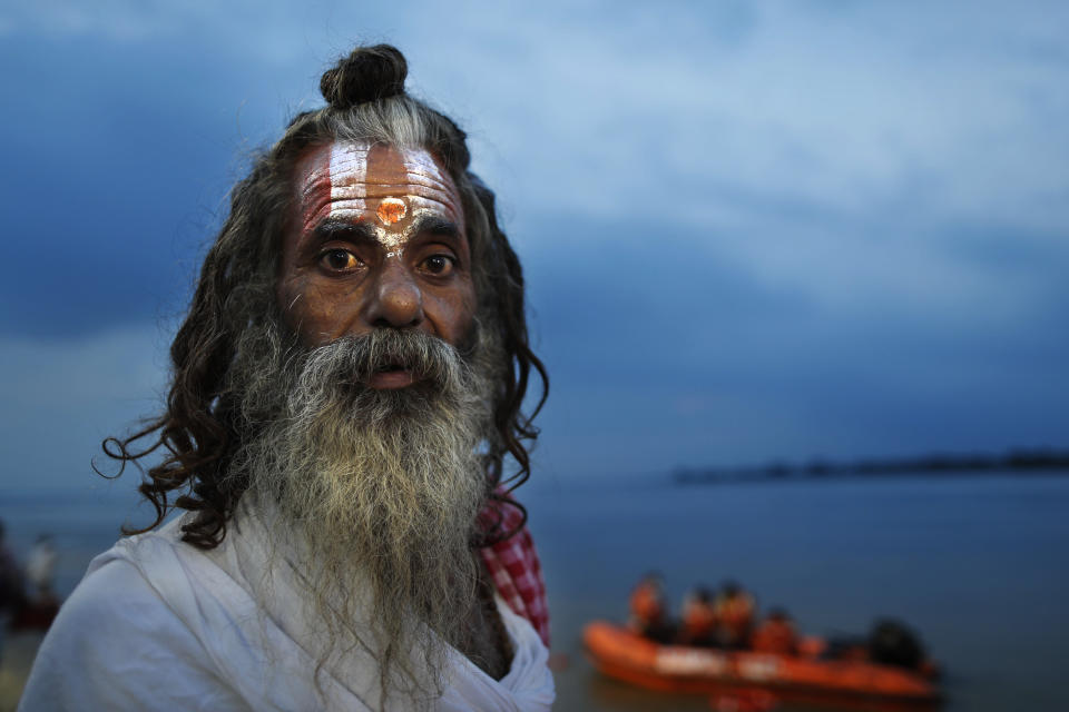 A Hindu holy man looks at a decoration on the ghats of the river Saryu as part of preparations for the groundbreaking ceremony of a temple to the Hindu god Ram in Ayodhya, in the Indian state of Uttar Pradesh, Monday, Aug. 3, 2020. As Hindus prepare to celebrate the groundbreaking of a long-awaited temple at a disputed ground in northern India, Muslims say they have no firm plans yet to build a new mosque at an alternative site they were granted to replace the one torn down by Hindu hard-liners decades ago. (AP Photo/Rajesh Kumar Singh)