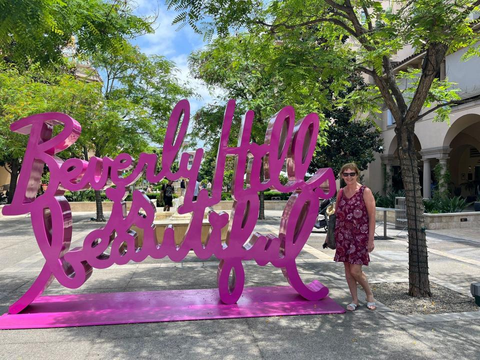 Writer's mother poses with a sign that says "Beverly Hills Beautiful"