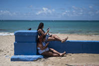 Women relax on the shores of the Ultimo Trolley public beach during a vaccination campaign as part of the “Noche de San Juan” festivities, a traditional all-day celebration to mark the birth of St. John the Baptist, in San Juan, Puerto Rico, Wednesday, June 23, 2021. This year COVID-19 vaccines will be available to devotees heading to the beach to celebrate the saint’s June 24th feast day. (AP Photo/Carlos Giusti)