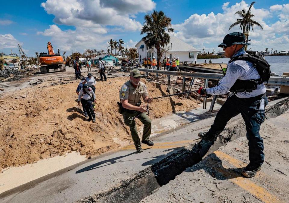 Charles Brodbeck, rescue specialist for Urban Search and Rescue Florida Task Force 1, assists Sgt. John Parsons with the Department of Agriculture and Consumer Services climb the Matlacha bridge damaged during Hurricane Ian, Tuesday, October 4, 2022.