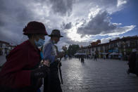 Members of the Tibetan Buddhist faithful spin prayer wheels as they circumambulate around the Jokhang Temple in Lhasa in western China's Tibet Autonomous Region, as seen during a rare government-led tour of the region for foreign journalists, Tuesday, June 1, 2021. Long defined by its Buddhist culture, Tibet is facing a push for assimilation and political orthodoxy under China's ruling Communist Party. (AP Photo/Mark Schiefelbein)