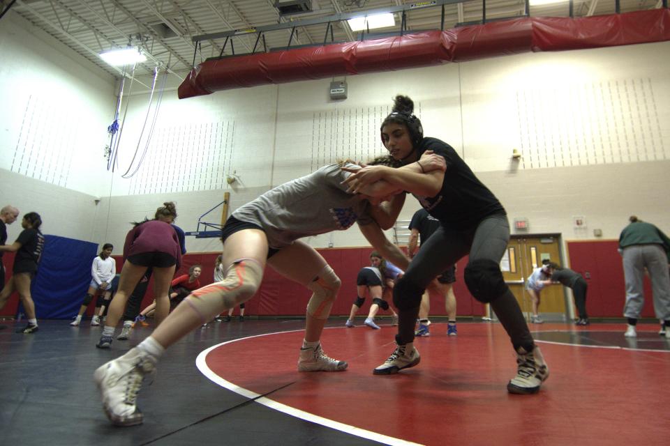 Jody Mikhail, front right, wrestles teammate Eliana White-Vega, front left, at a Cumberland Valley High School team practice Tuesday, Feb. 27, 2024, in Mechanicsburg, Pa. Mikhail, a senior, began wrestling three years ago when she saw a poster in school for the girls' wrestling club. White-Vega, also a senior, won a silver medal at the 2023 U17 Pan-American Championships. (AP Photo/Marc Levy)