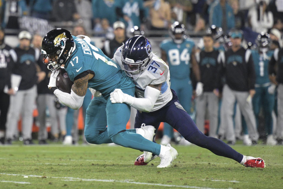 Jacksonville Jaguars tight end Evan Engram (17) is tackled by Tennessee Titans safety Amani Hooker (37) in the first half of an NFL football game, Saturday, Jan. 7, 2023, in Jacksonville, Fla. (AP Photo/Phelan M. Ebenhack)