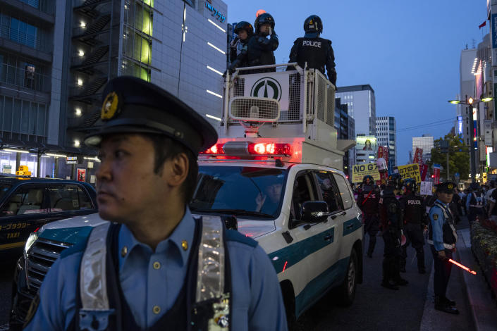 Police officers stand guard as protesters gather near the famed Atomic Bomb Dome ahead of the Group of Seven nations' meetings in Hiroshima, western Japan, Wednesday, May 17, 2023. (AP Photo/Louise Delmotte)