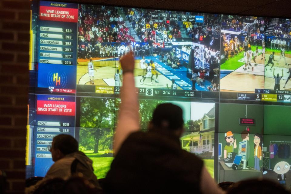 A man raised his arm in celebration while watching the March Madness tournament in 2023 in Delaware.