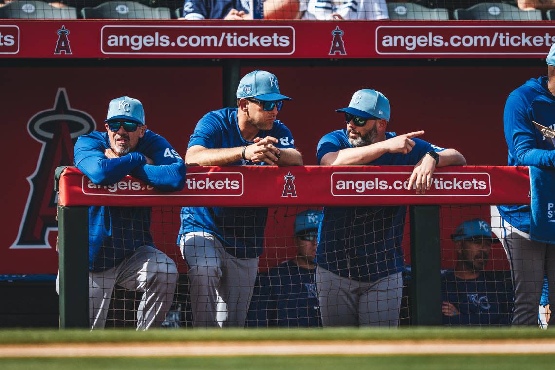 Royals bench coach Paul Hoover, left, assistant pitching coach Zach Bove, center, and major league pitching strategist Andy Ferguson confer in the dugout during a game at Angel Stadium in Anaheim, Calif.