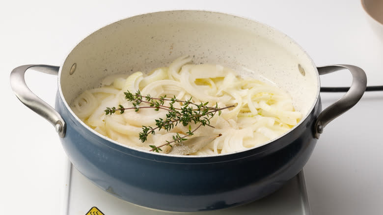 onions and herbs in pan