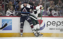 Colorado Avalanche left wing J.T. Compher, left, checks Minnesota Wild left wing Kevin Fiala in the first period of an NHL hockey game Monday, Jan. 17, 2022, in Denver. (AP Photo/David Zalubowski)