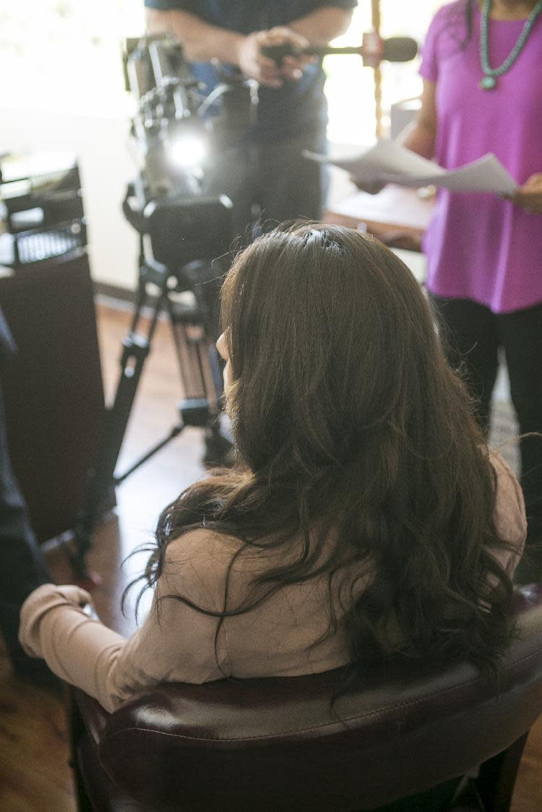 A woman who wanted to be identified by her first name, Brianna, is interviewed by a television news crew after a news conference in Pasadena, Calif., Thursday, Jan. 23, 2014. The woman came forward to claim that a California educator sexually abused her, saying she decided to speak out after watching a YouTube video by another woman who made similar accusations. Police are investigating the allegations from both women, who say the former teacher and administrator Andrea Cardosa abused them while they were students. (AP Photo/Damian Dovarganes)