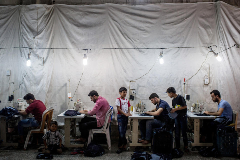 <p>Syrian refugees work in a Syrian-owned clothing factory on May 17, 2016, in Gaziantep, Turkey. Turkey’s massive and largely unregulated garment industry is an attractive option for Syrian refugees to work both legally and illegally despite low wages, long hours and poor conditions. It is a popular choice for Syrians living outside of the official refugee camps, who are offered no assistance from the state. (Chris McGrath/Getty Images) </p>