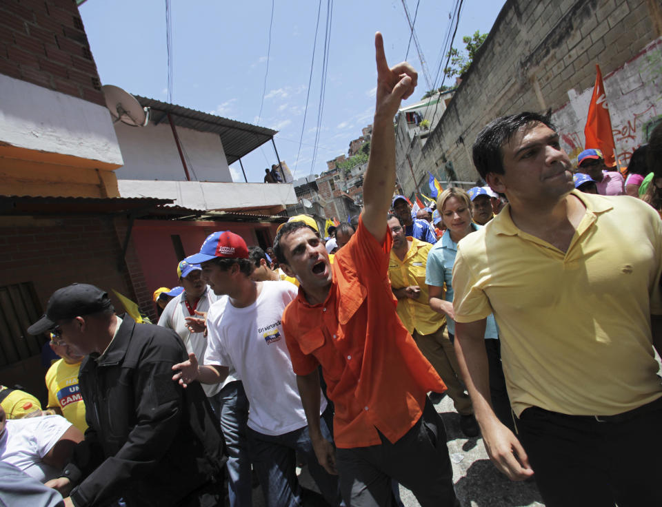 Opposition's presidential candidate Henrique Capriles, center, greets supporters during a campaign rally in Caracas, Venezuela, Sunday, Sept. 16, 2012. Capriles is running against President Hugo Chavez in the country's Oct. 7 election. (AP Photo/Fernando Llano)