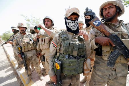 Iraqi army soldiers stand with their weapons in center of Falluja, Iraq, June 17, 2016. REUTERS/Thaier Al-Sudani