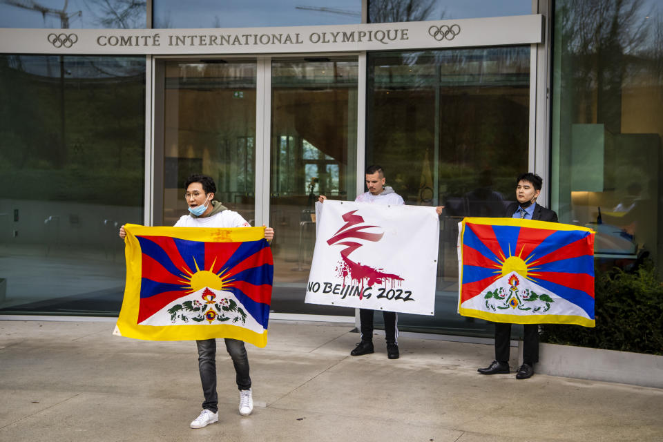 Protesters hold Tibetan flags during a protest against Beijing 2022 Winter Olympics by activists of the Tibetan Youth Association in Europe, in front of the International Olympic Committee, IOC, headquarters in Lausanne, Switzerland, Wednesday, Feb. 3, 2021. A coalition of 180 rights groups is calling for a boycott of next year's Beijing Winter Olympics tied to reported human rights abuses in China. The games are to open on February 4, 2022. The coalition is made up of groups representing Tibetans, Uighurs, Inner Mongolians and others. The group has issued an open letter to governments calling for a boycott of the Olympics “to ensure they are not used to embolden the Chinese government’s appalling rights abuses and crackdowns on dissent.” (Jean-Christophe Bott/Keystone via AP)