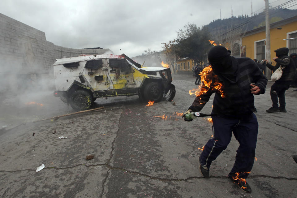 A demonstrator is engulfed in flames from a petrol bomb that was thrown at a police vehicle during protests marking the anniversary of the coup that toppled President Salvador Allende and brought dictator General Augusto Pinochet to power 49 years ago, in Santiago, Chile, on Sept. 11, 2022. (AP Photo/Luis Hidalgo)