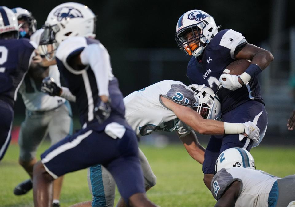 Xanai Scott of Dwyer High (3) gains a few yards as Easton Scott (21) closes in for the tackle for Jensen Beach High on Friday, September 1, 2022 in Palm Beach Gardens.