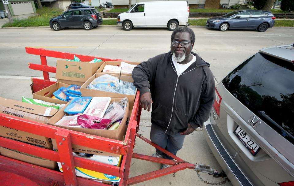 Maurice Allen, president of Street Warriors, middle, poses for a portrait near his van and trailer, one of many vehicles used to transport food to food pantries Friday, Sept. 23, 2022, at Spirit of Peace Lutheran Church located at 5505 W. Lloyd St., Milwaukee. Maurice has been going into debt filling up vehicles to transport food to various food pantries. 'We're helping people,' he said. 'That's what it is all about.'